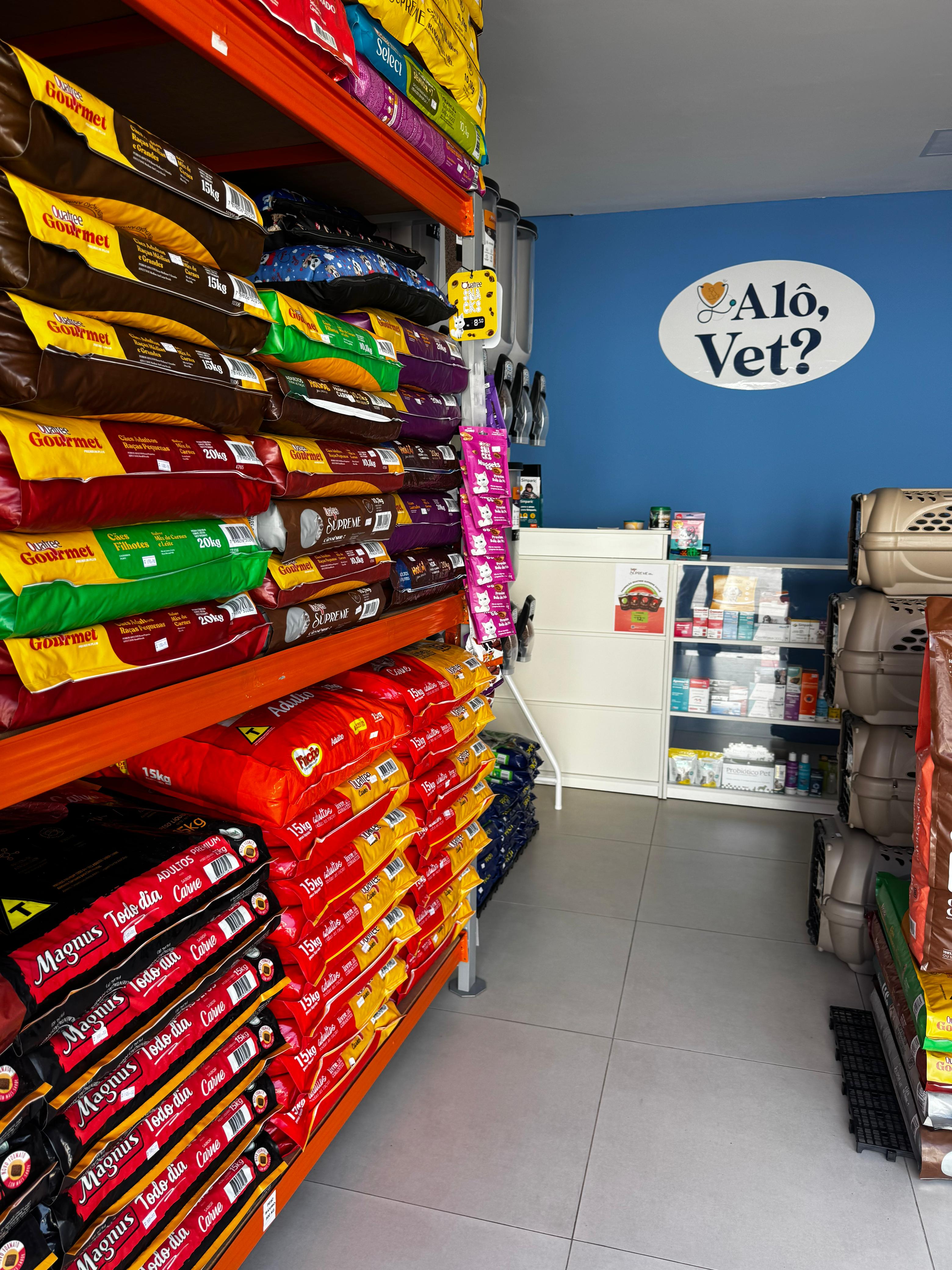 Corredor de prateleiras do pet shop Alô, Vet? com produtos organizados